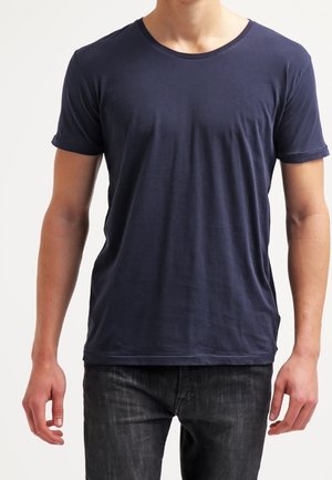 Bawełniana koszulka w kolorze granatowym z okrągłym dekoltem i krótkimi rękawami. Miękka tekstura, luźny krój i minimalistyczny design bez widocznych wzorów.