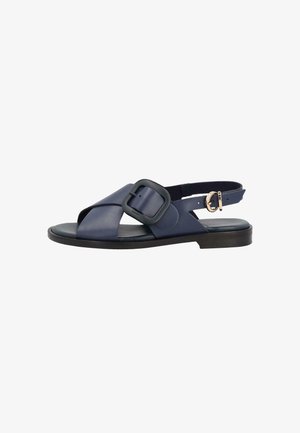 Sandalo basso blu navy con cinturini incrociati, grande fibbia quadrata sulla parte superiore e fibbia rotonda più piccola dorata sulla cavigliera.