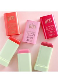 Rødmerker i pink, koral og rød nuancer med grøn og pink emballage. Hver stift har en blank finish og markant branding.