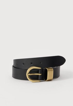 Cinturón de cuero negro con hebilla redonda de metal dorado y pasador dorado, exhibido enrollado sobre fondo blanco.