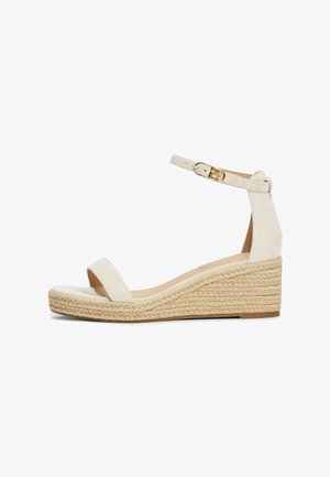 Sandale compensée blanche en daim avec bride à la cheville, talon en jute et design à bout ouvert. Elle comprend une boucle métallique pour l'ajustement.