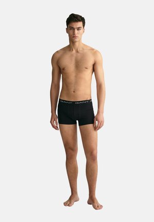 Schwarze Boxershorts aus glattem Material mit einem breiten elastischen Bund, der den Markennamen trägt. Das Material wirkt glatt und angepasst für maximalen Komfort.