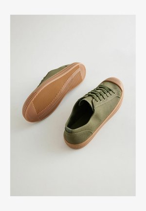 Olivově zelené plátěné tenisky s kulatou špičkou, šněrováním vpředu a texturovanou gumovou podrážkou v barvě tan. Obsahují vyšívací detaily a polstrovaný límec.