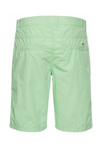 Lichtgroene shorts van een gestructureerde stof, met twee achterzakken en een subtiele logo-detail aan de rechterkant.