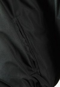 Black fabric featuring a smooth texture. The design includes a concealed pocket on the left side, emphasizing minimalist style.