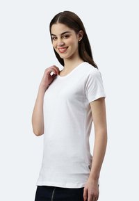 Weißes T-Shirt mit kurzen Ärmeln aus weichem Baumwollstoff, mit Rundhalsausschnitt und schmalem Schnitt, versehen mit einem dezenten seitlichen Etikett.