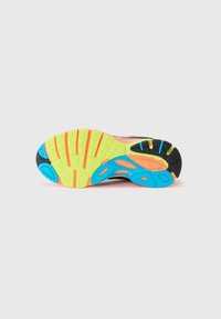 Shoe sole featuring a black base with colorful accents in blue, orange, and yellow. Textured for grip with distinct traction patterns.