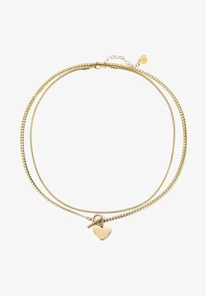 Collar de múltiples hebras en oro con un charm en forma de corazón, que presenta una mezcla de eslabones de cadena lisos y texturizados, y un cierre tipo toggle.