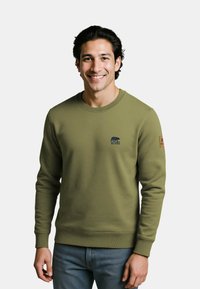 Olijfgroen sweatshirt met geribbelde manchetten en onderrand, voorzien van een klein blauw berenlogo op de borst en een bruine label op de mouw.