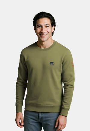 Olivgrüner Sweatshirt mit gerippten Bündchen und Saum, ausgestattet mit einem kleinen blauen Bärenlogo auf der Brust und einem braunen Etikett am Ärmel.