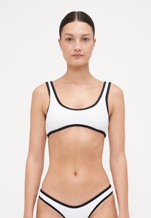 White bikini top with a textured fabric, featuring black trim and straps. The design includes a scoop neckline and a fitted shape.