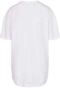 Balto medvilnės T-shirt'as, su laisvu kirpimu, trumpomis rankovėmis, apvaliu iškirpimu ir vientisu nugara. Lygus paviršius, be matomų raštų ar grafikos.