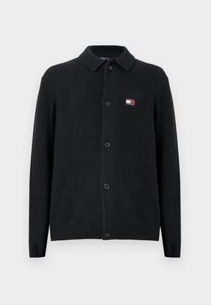 Black wool cardigan featuring a collared neckline, button front, and ribbed cuffs. Small logo patch in red, white, and blue on the left chest.