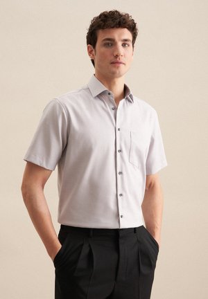 Koszulka z krótkim rękawem w jasnoszarym kolorze, z kołnierzykiem zapinanym na guziki, przednią kieszenią i ciemnymi guzikami. Gładka tkanina z delikatnymi detalami fakturowymi.