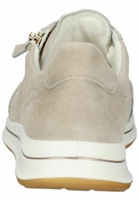 Beige Wildlederschuh mit weißer Sohle, runder Form und kontrastierendem cremefarbenem Innenfutter. Verfügt über einen silbernen Reißverschlussakzent auf der Rückseite.