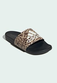 Sandały Adidas z paskiem w leopardzim wzorze, czarną podeszwą i wyraźnym białym logo. Miękki materiał i otwarty przód dla komfortu.