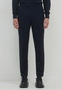 Pantaloni blu navy su misura realizzati in tessuto leggero con una texture liscia, dotati di chiusura frontale con zip e bottone, e tasche laterali.