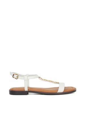 Witte platte sandaal met een T-strap ontwerp, gouden kettingaccent en een verstelbare enkelgesp. Beschikt over een soepele leren bovenkant en een bruine zool.