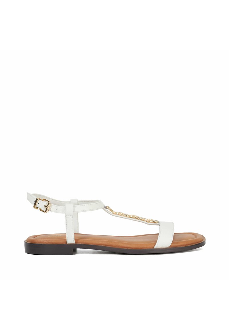 Witte platte sandaal met een T-strap ontwerp, gouden kettingaccent en een verstelbare enkelgesp. Beschikt over een soepele leren bovenkant en een bruine zool.