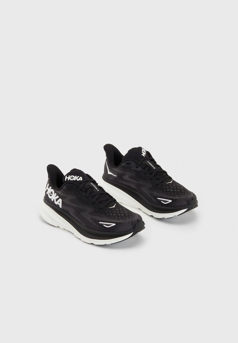 Scarpe da corsa nere con una tomaia in mesh testurizzato, logo bianco, colletto imbottito e una spessa intersuola bianca per l'ammortizzazione.