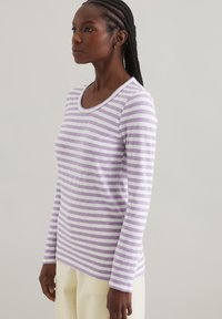 Gestreiftes Langarmoberteil in Helllila und Weiß, mit rundem Halsausschnitt und weichem, strukturiertem Stoff. Gerade Passform mit fallenden Schultern.