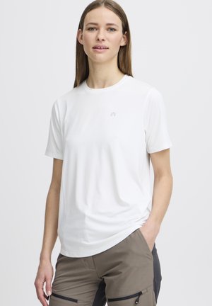 Tricou alb cu mânecă scurtă, guler rotund, material ușor, logo subtil pe piept, asortat cu pantaloni cargo bej cu buzunare cu fermoar.