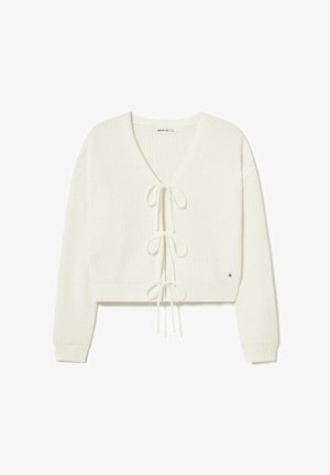Cardigan corto blanco de punto con mangas largas y tres lazos decorativos en la parte delantera.