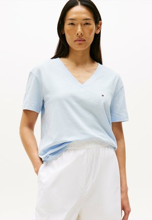 Lichtblauwe V-hals T-shirt van zachte katoen met korte mouwen, met een klein logo op de linkerborst. Draagt men met witte broek.