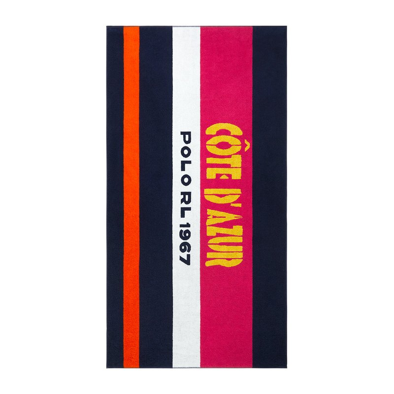 Πετσέτα παραλίας με έντονες ρίγες σε ναυτικό μπλε, πορτοκαλί, λευκό, ροζ και κίτρινο, με τις επιγραφές «CÔTE D'AZUR» και «POLO RL 1967» να ξεχωρίζουν. Απαλή υφή.