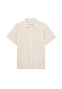 Chemise à manches courtes de couleur crème en tissu texturé, dotée d'un col boutonné à l'avant et d'une poche poitrine unique. L'étiquette sur le col indique "LES DEUX."