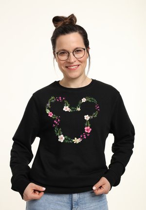 Felpa nera con un design floreale a forma di contorno di Topolino, con fiori rosa e bianchi e foglie verdi.