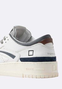 Sneaker bianco con lacci grigi, accenti blu navy e marroni, colletto imbottito e "D.A.T.E." impresso sulla suola vicino al tallone.