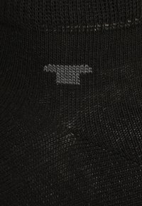 Black sock featuring a subtle gray logo design at the ankle, made of a smooth, stretchy material with fine texture.