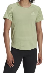 Jasnozielona sportowa koszulka z krótkimi rękawami, okrągłym dekoltem i teksturowaną tkaniną. Na piersi znajduje się logo Adidas oraz wzory wentylacyjne.