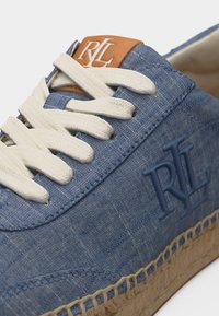 Μπλε πάνινο αθλητικό παπούτσι με λευκά κορδόνια, λογότυπο RL στο πλάι και στη γλώσσα, και υφασμένο μπεζ σόλα τύπου εσπαντρίγιες.