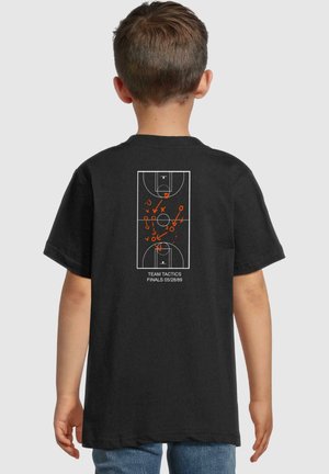 Camiseta negra con un diseño de cancha de baloncesto en blanco y naranja en la parte de atrás, que detalla las tácticas del equipo y la fecha final, 28/05/89.