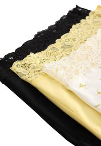 Tre paia di mutandine con pizzo: nere, gialle e bianche con un motivo floreale. Eleganti bordi in pizzo adornano la parte superiore per un tocco di dettaglio in più.
