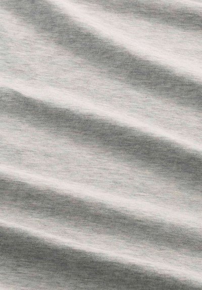Tissu doux gris clair avec de subtils plis diagonaux et une texture fine en maille créant des ombres et des reflets délicats.