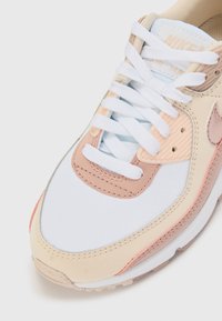 Nike Air Max sportbačiai su balta ir kreminė oda, rausvais akcentais, baltais raišteliais ir tekstūruotais elementais.