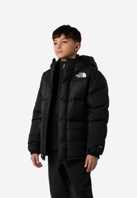 Geacă neagră matlasată cu glugă, realizată din material captusit. Prezintă un logo alb pe piept, închidere cu fermoar și manșete elastice.