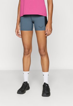 Gray athletic shorts with black accents and a logo, paired with a pink top, white socks, and black shoes, showcasing a fitted design.