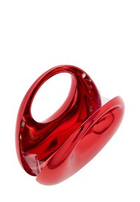 Rode, glanzende plastic tas met een holle handgreep. Glad, gebogen ontwerp en naadloze body, met subtiele reflecterende oppervlakte-details.