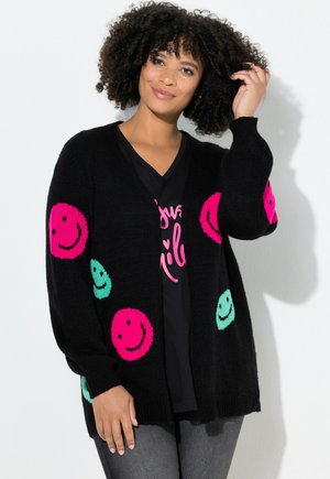 Cardigan noir avec une coupe décontractée, arborant des motifs de visages souriants roses et turquoise. Fabriqué en matériau tricoté doux avec des manches longues.