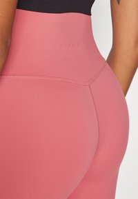 Leggings s visokim strukom u mekoj ružičastoj tkanini. Imaju glatku teksturu, ravne šavove i diskretni logo "ONLY PLAY" na pojasu.