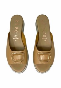 Sandali a scivolo in pelle color talpa con una fascia larga e un'intera accentuazione dorata rettangolare. Presentano una soletta imbottita e un tacco leggero per il massimo comfort.