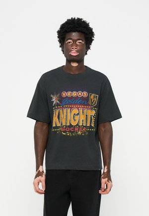 Black cotton t-shirt featuring bold multicolored print with "VEGAS GOLDEN KNIGHTS HOCKEY" text, short sleeves, loose fit. Casual style.