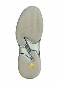 Suola della scarpa con una base in gomma traslucida, motivo a spina di pesce per la trazione e un dettaglio del sistema di torsione in argento; presenta il logo Adidas giallo.