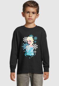 Langärmliges schwarzes T-Shirt mit einem bunten Grafikdesign eines Charakters mit blonden Haaren, umgeben von Schneeflockenmuster und dem Namen "Elsa".