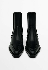 Czarne skórzane botki za kostkę z szpiczastymi noskami i eleganckim designem. Posiadają wysmuklone szwy i niski, kwadratowy obcas.