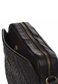 Bolso de cuero negro trenzado con cierre de cremallera y herrajes dorados, bordes redondeados y una textura suave.
